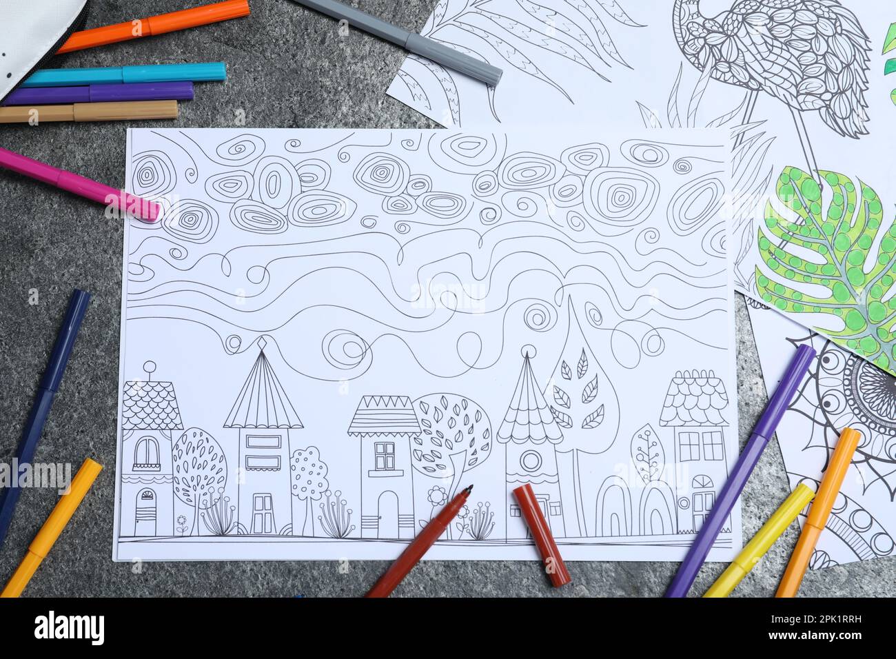 Antistress coloring pages and felt tip pens on grey table flat lay stock photo