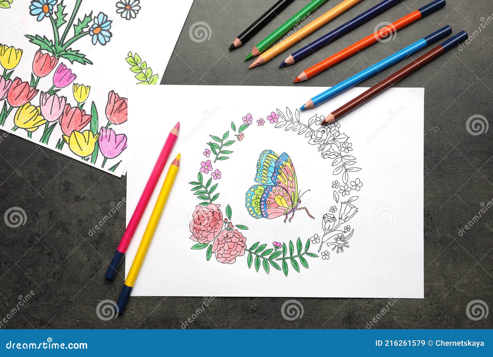 Coloring pages with children drawings and set of pencils on grey table flat lay stock image