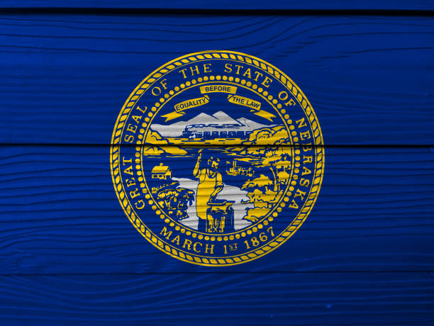 Nebraska flag color painted on fiber cement sheet wall background seal of nebraska in gold on an azure field stock photo