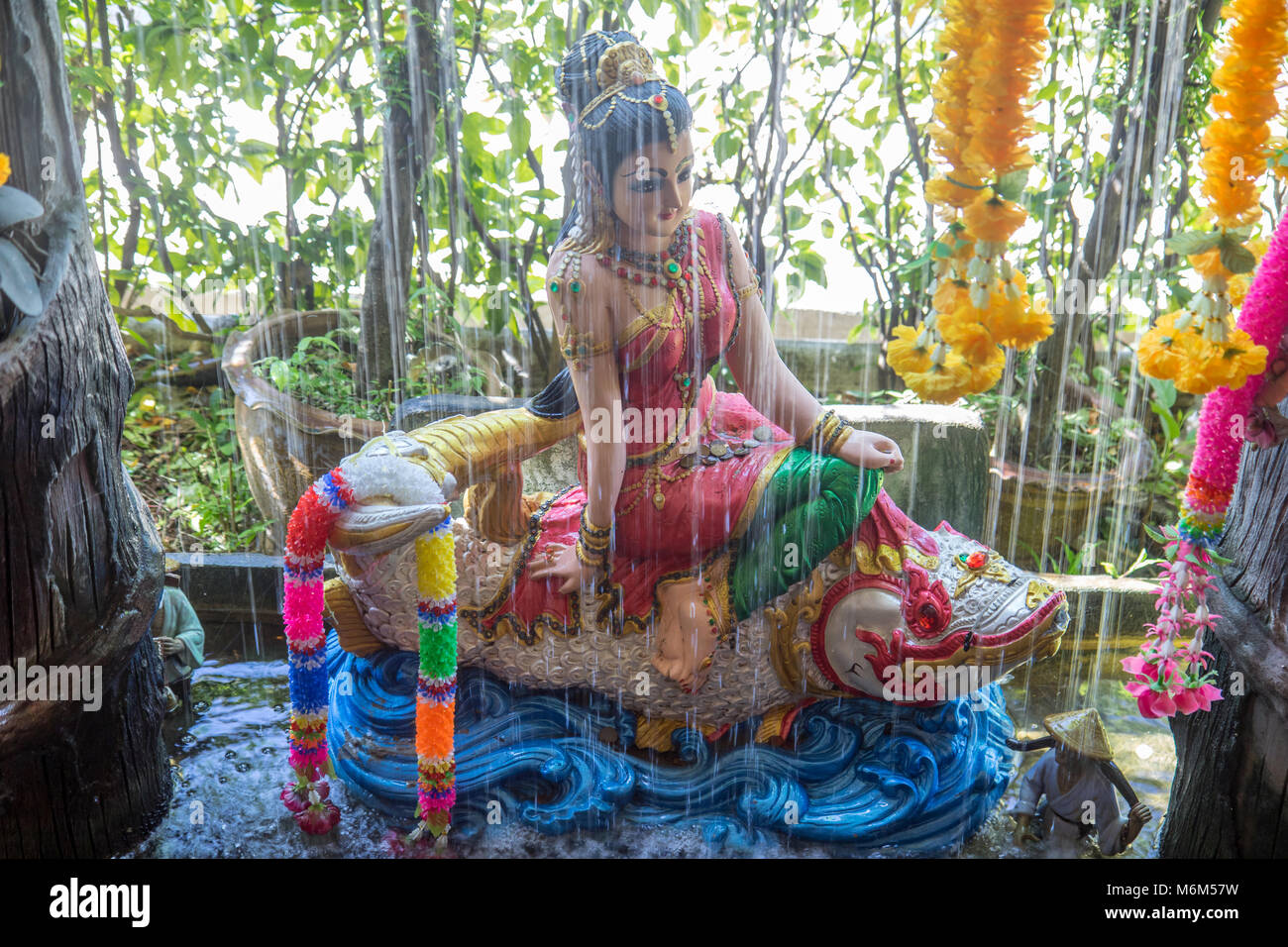 Phra mae thorani goddess from buddhist mythology behind water of fountain stock photo
