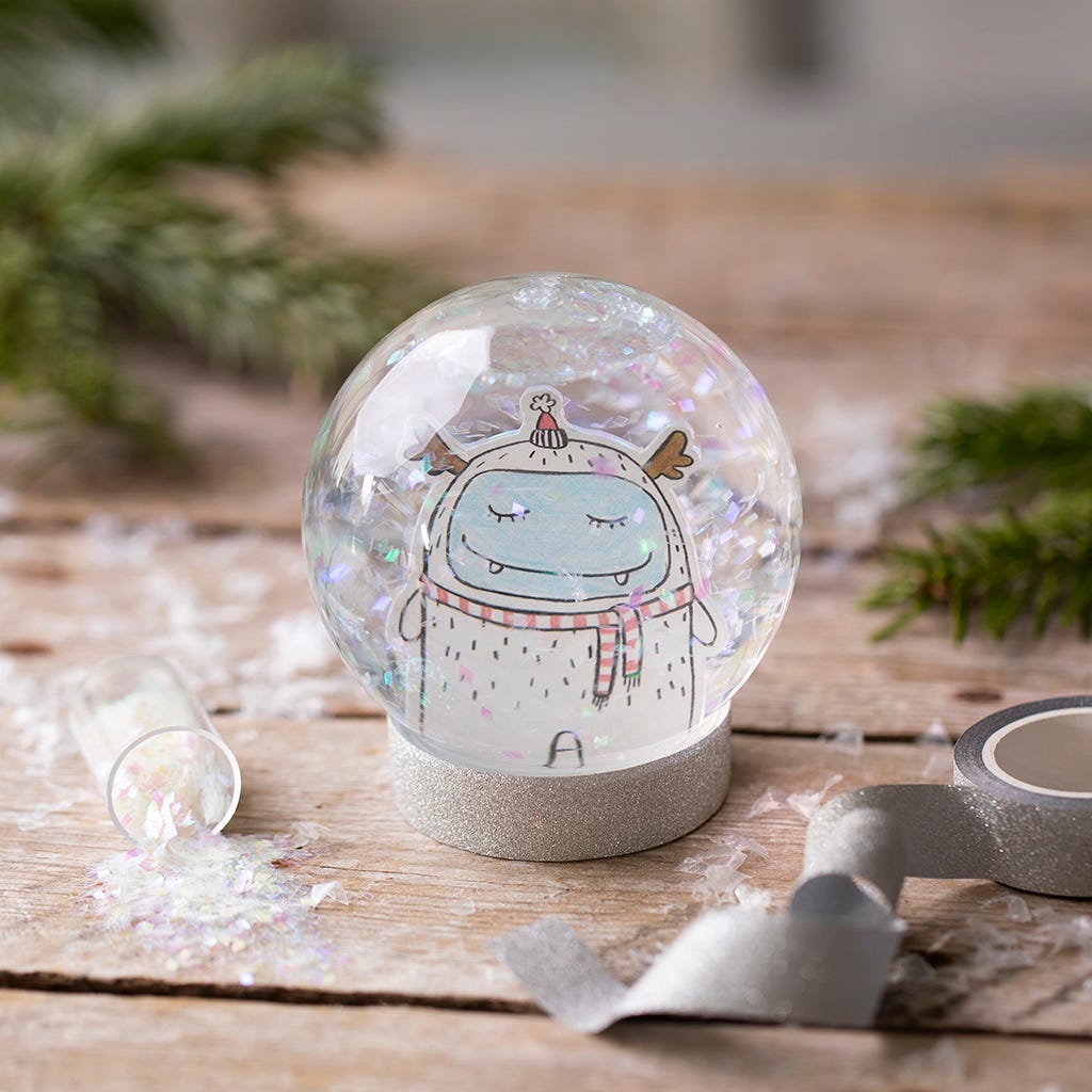 A snow globe with a drawing and glitter