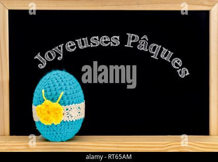 Joyeuses pãques is happy easter written in french on a label in a wicker basket filled with eggs and tulips stock photo