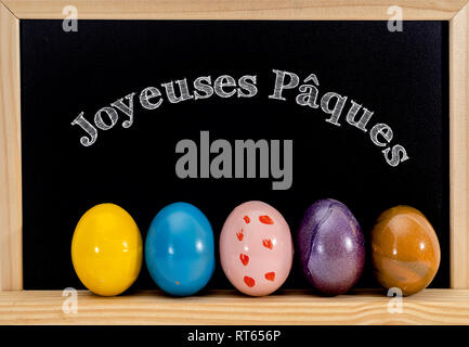 Joyeuses pãques is happy easter written in french on a label in a wicker basket filled with eggs and tulips stock photo