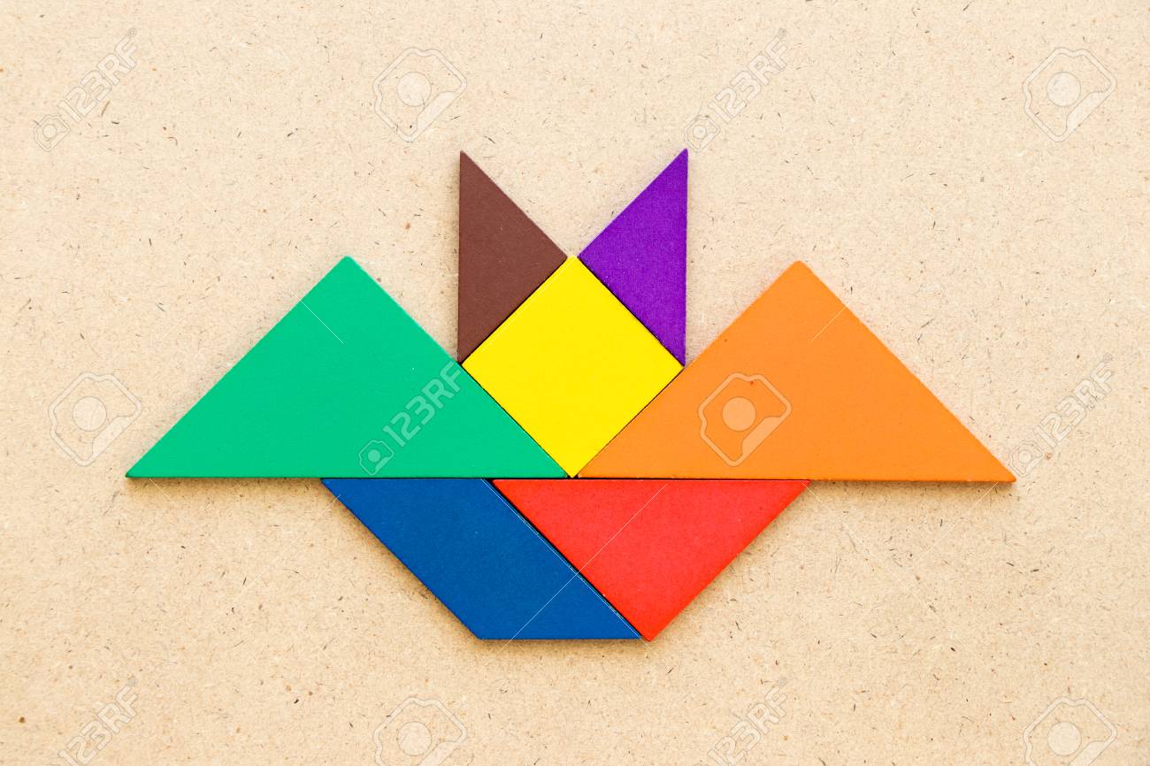 Color tangram in flying bat shape on wood background stock photo picture and royalty free image image