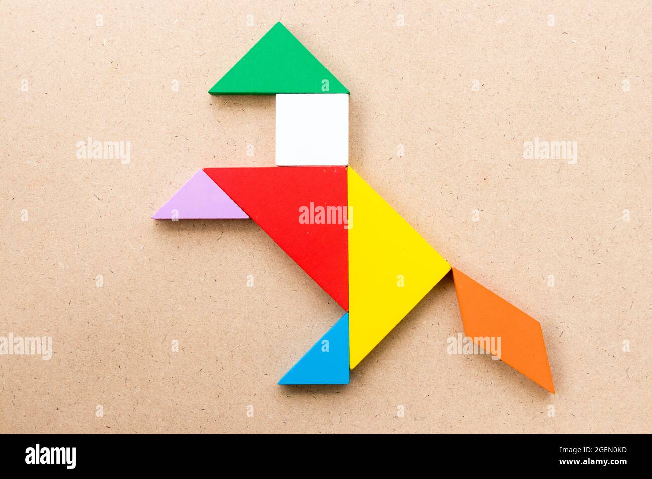 Color tangram puzzle in exciting horse shape on wood background stock photo