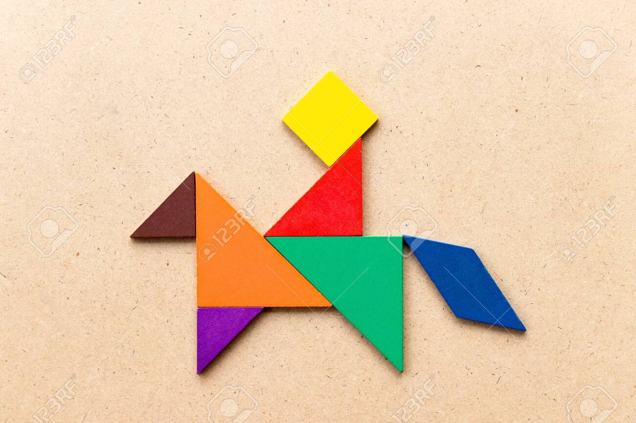 Color tangram puzzle in man ride on the horse shape shape on wood background stock photo picture and royalty free image image