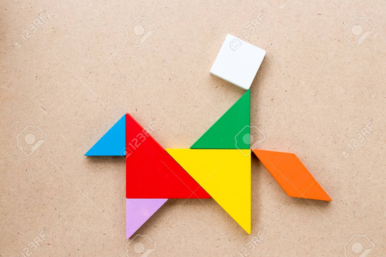 Color tangram puzzle in man ride horse shape on wood background stock photo picture and royalty free image image