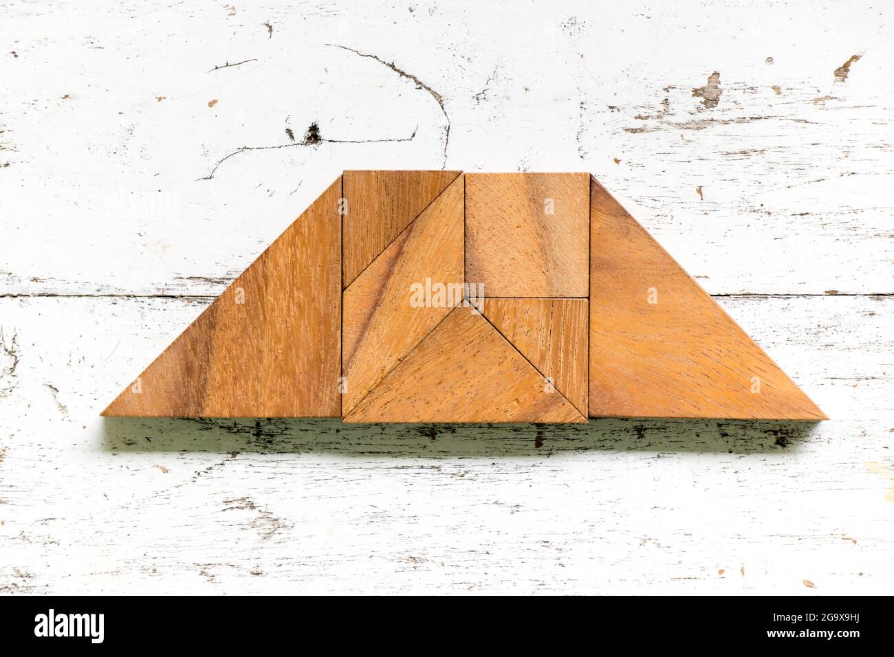 Tangram puzzle in trapezoid or trapezium shape on old white wood background stock photo